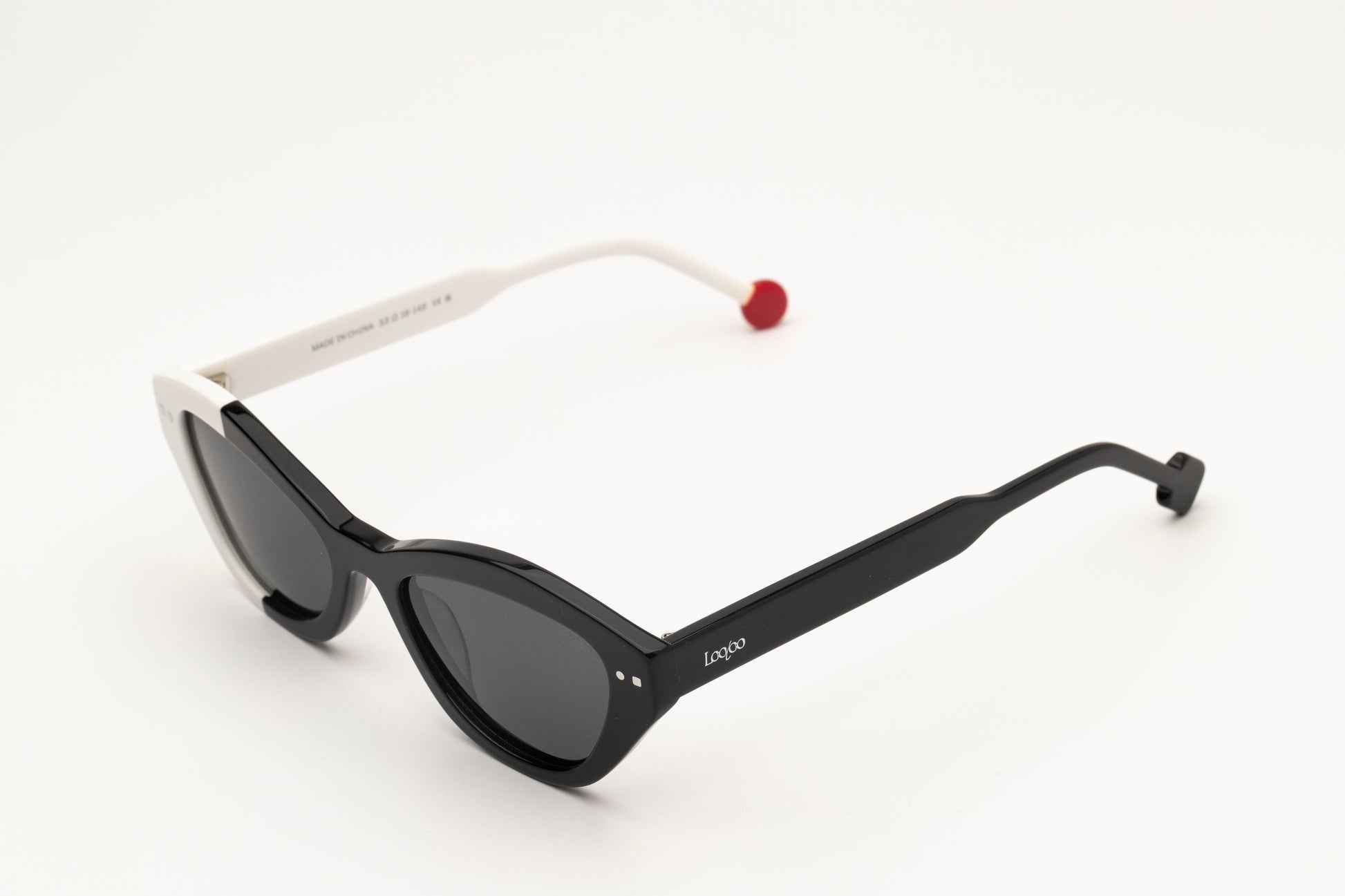Sunglasses with black and white acetate frame on a white background.