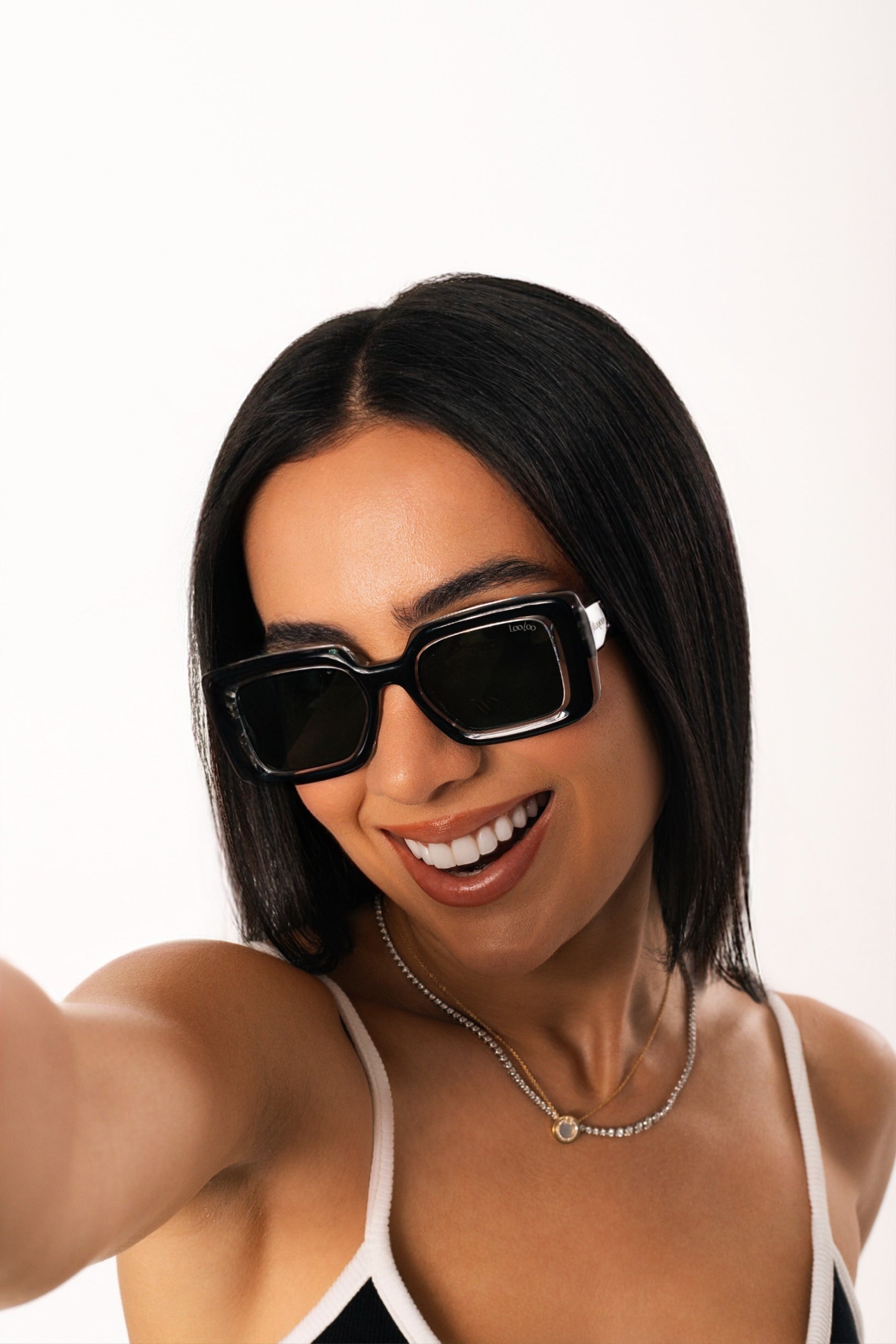 Woman wearing a pair of black and crystal acetate frame, on a white background.