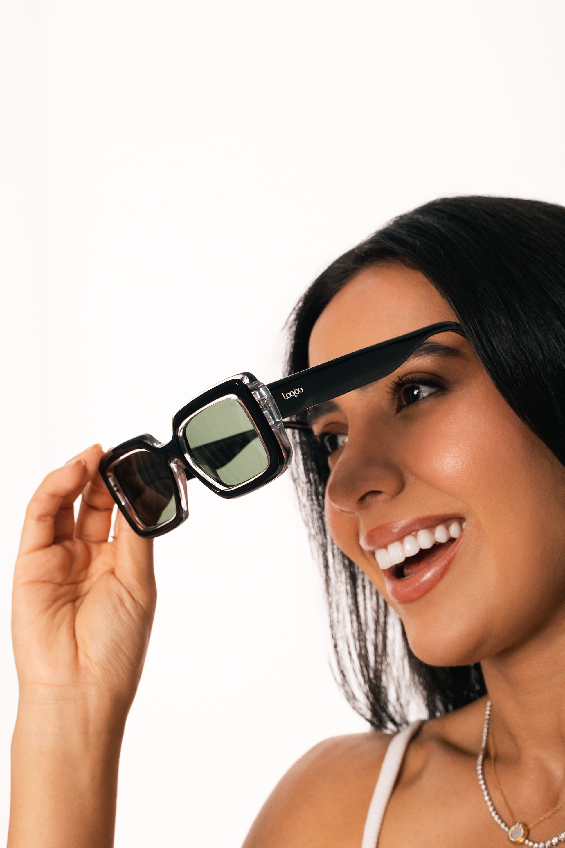 Woman wearing a pair of black and crystal acetate frame, on a white background.