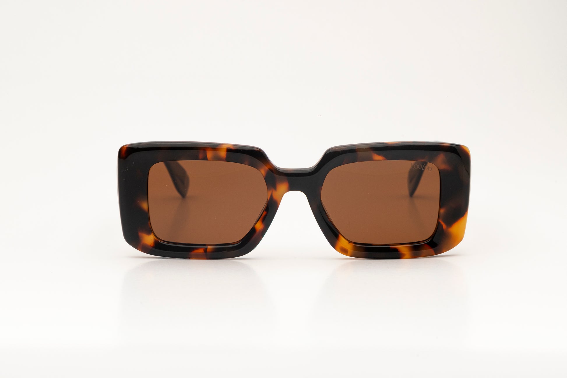 Sunglasses with tortoise acetate frame with brown lenses on a white background.