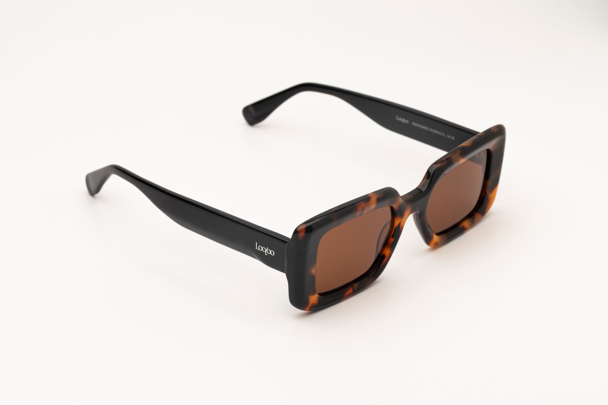 Sunglasses with tortoise acetate frame with brown lenses on a white background.