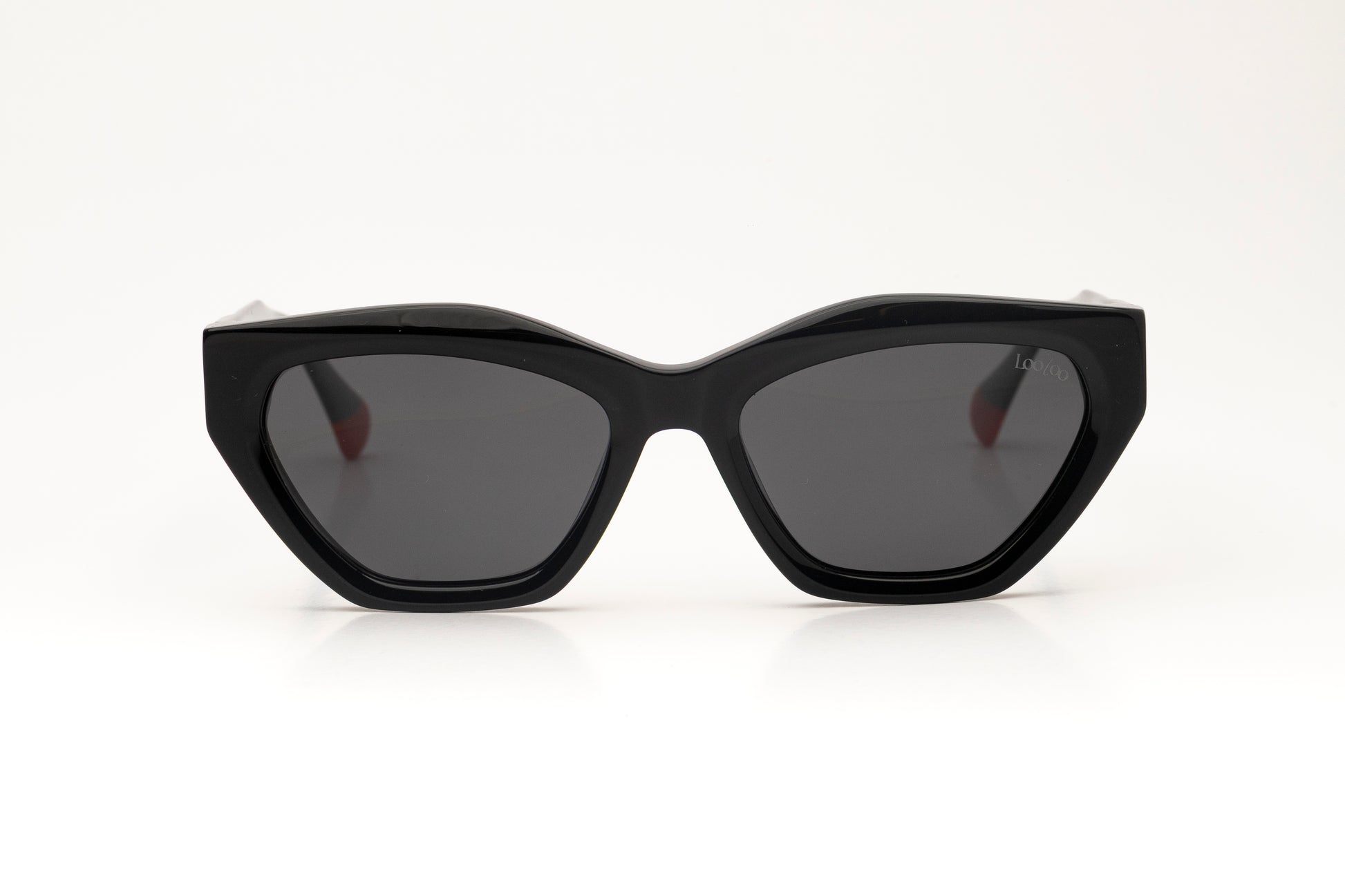 Sunglasses with black acetate frame, with red detail, on a white background.
