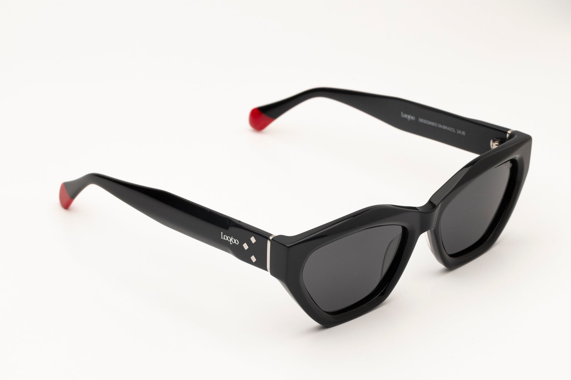 Sunglasses with black acetate frame, with red detail, on a white background.
