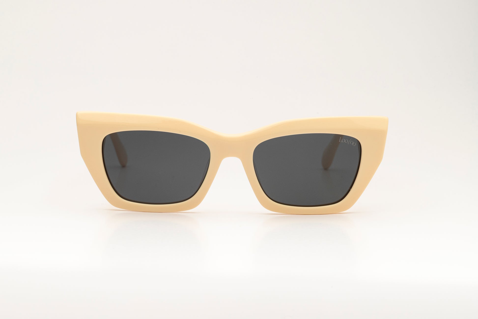 Sunglasses with beige acetate frame on a white background.