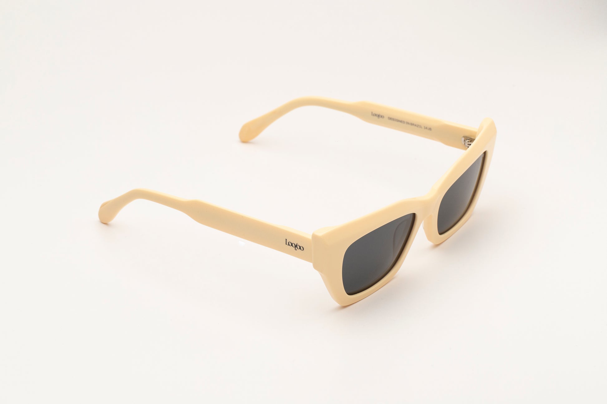 Sunglasses with beige acetate frame on a white background.