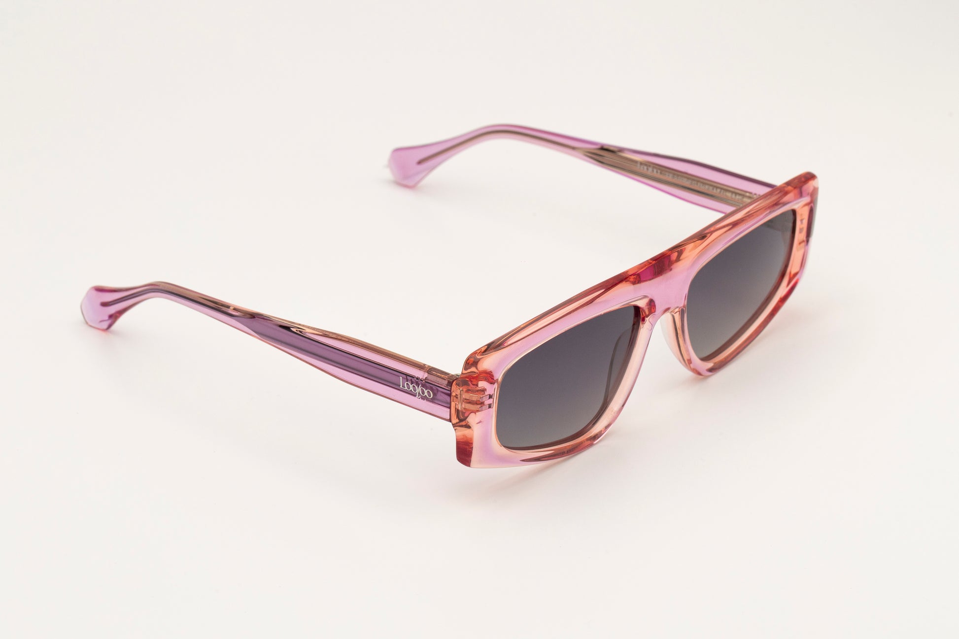 Sunglasses with pink acetate frame on a white background.
