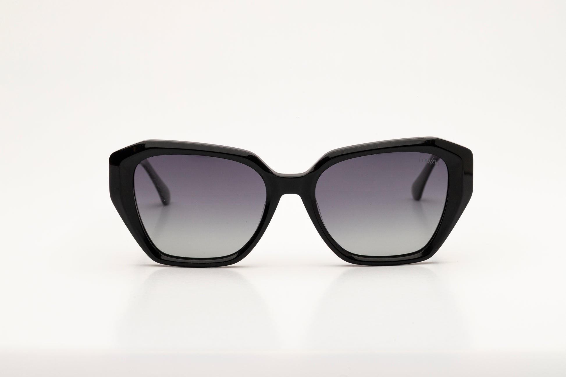 Sunglasses with black acetate frame and gradient lenses on a white background