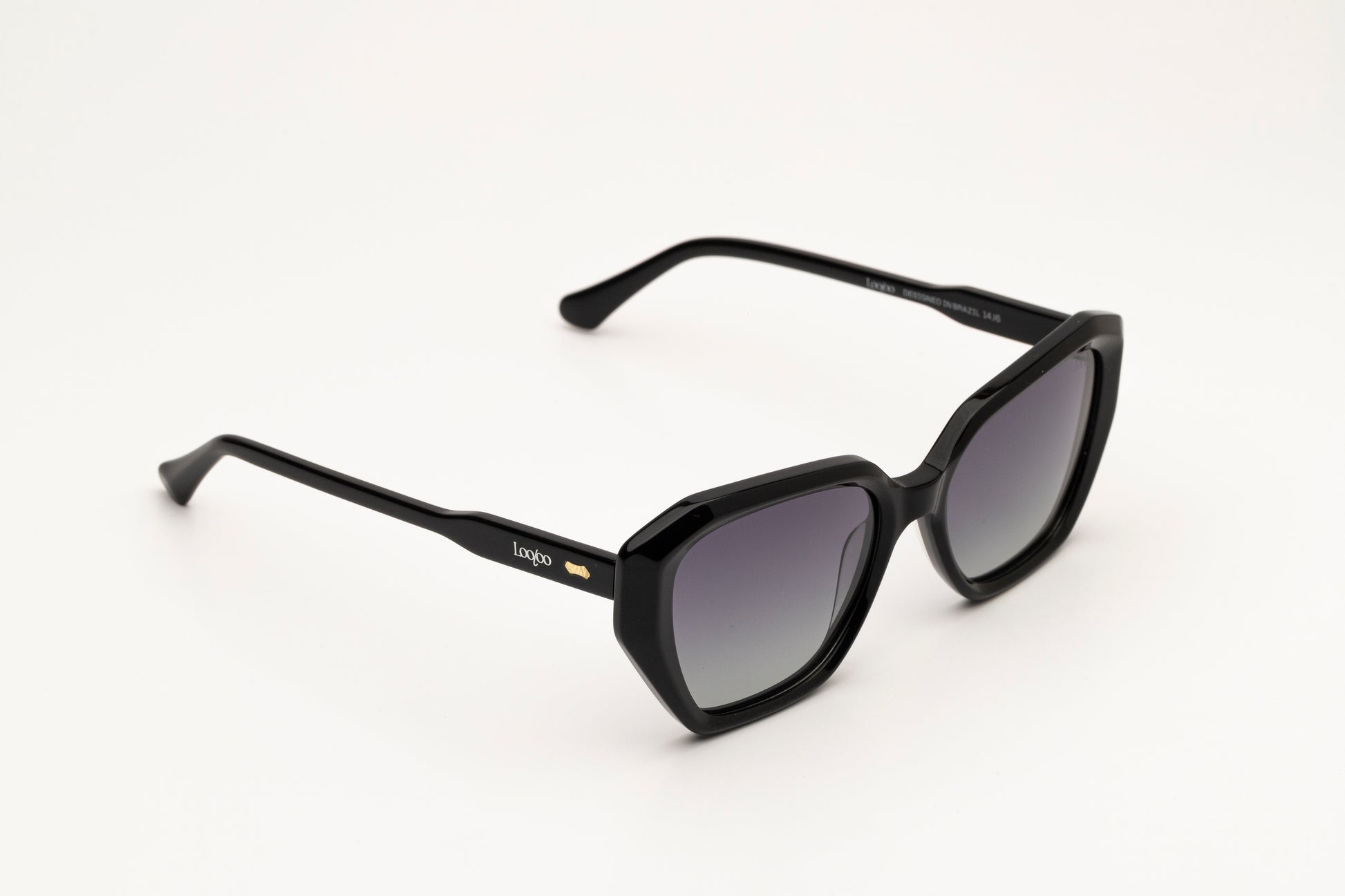 Sunglasses with black acetate frame and gradient lenses on a white background.